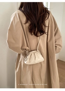 Dettaglio della borsa nuvola a pieghe beige con tracolla a nodo sottile sulla schiena