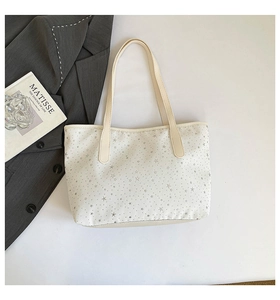 Détail du sac fourre-tout en toile blanche avec motif d'étoiles grises et anses longues