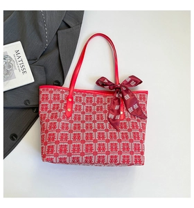 Top view of red canvas tote bag featuring white Xi patterns and a decorative silk bow