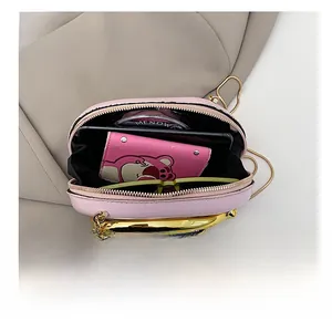 Internal view of pink semi-circular handbag showing storage for phone and accessories