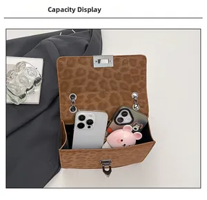 Detail view of leopard print crossbody bag interior capacity with smartphones and accessories