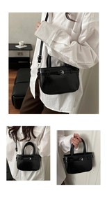 Détail du sac bandoulière en cuir verni noir avec boucle argentée et bandoulière réglable