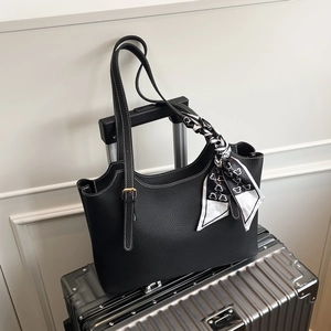 Borsa tote in pelle martellata nera con sciarpa di seta e cuciture bianche su valigia d'argento