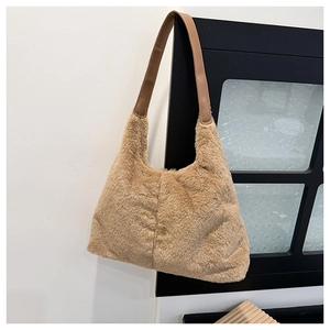 Dettaglio borsa tote in ecopelliccia kaki con manici in pelle marrone su cornice nera