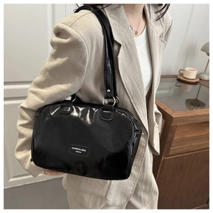 Détail du sac cabas en cuir verni noir brillant avec anneaux argentés et logo chic