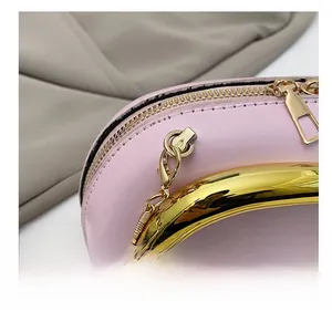 Detailed close-up of pink leather handbag with gold zipper and snake chain strap