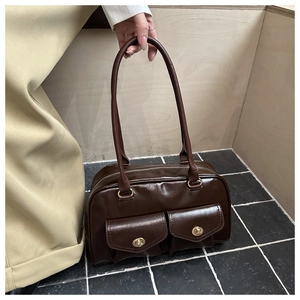 Detail of dark brown faux leather shoulder bag with dual gold twist-lock front pockets