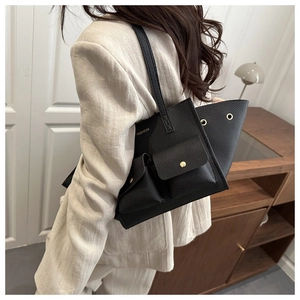 Dettaglio della borsa tote nera in pelle martellata con tasche frontali e logo fashion