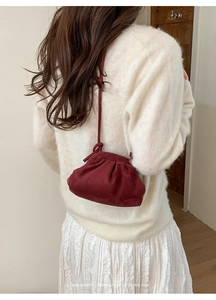 Una borsa a nuvola plissettata rosso vino dallo stile retrò minimalista sul modello