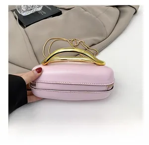 Pink glossy leather mini bag with gold curved metal handle and fine chain strap detail