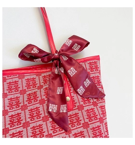 Detail of red festive tote bag showing silk scarf and white double happiness patterns