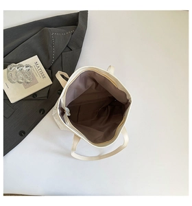 Détail du grand sac cabas beige montrant la doublure intérieure et la texture perforée
