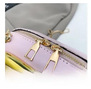 Close-up of smooth gold dual zippers on a premium light pink leather crossbody bag