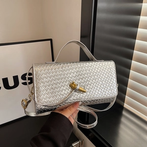 Silver shoulder bag with diamond weave texture and gold knotted clasp on white background