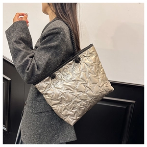 Détail du sac fourre-tout matelassé à étoiles, poignée en corde tressée et fini doré champagne