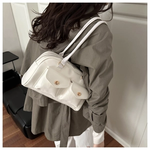 Detail of white leather underarm bag with gold twist locks and double front pocket design