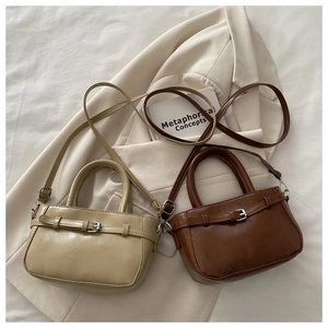 Detailed view of mini PU leather tote bags in beige and brown with buckle straps
