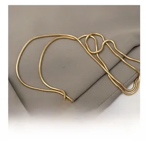 Detail of the high-quality gold snake chain strap on the light pink crossbody bag