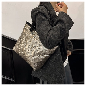 Détail du sac cabas matelassé à étoiles avec anses en corde épaisse sur modèle en blazer
