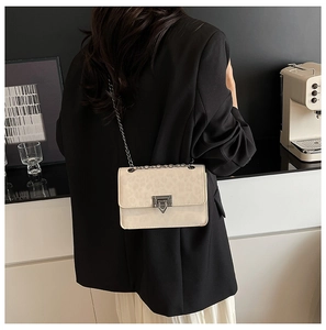Detail of leopard print chain bag featuring silver metallic buckle on black blazer