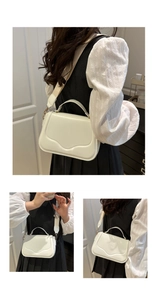 Detail of white leather handbag featuring wavy edge design and wide beige textile strap