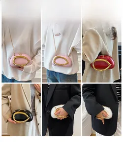 Macro shot of minimalist leather crossbody bag with iconic gold circular handle detail