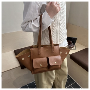Gros plan sur un sac cabas marron motif litchi avec deux poches et boucles dorées