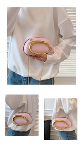 Detail view of pink patent leather handbag featuring irregular gold ring handle and chain