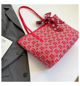 Close-up of a festive red tote bag with traditional pattern and decorative silk ribbon