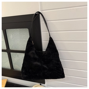 Dettaglio borsa hobo in ecopelliccia nera con tracolla in pelle liscia per l'inverno
