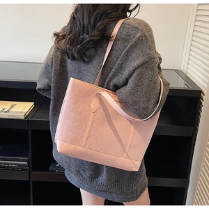 Detailed side view of the pink leopard print tote bag worn on shoulder by a model