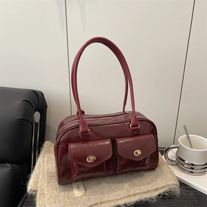 Deep red patent leather bowling handbag with double front pockets and gold locks