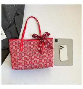 Detail of red festive tote bag with woven double joy pattern and decorative scarf