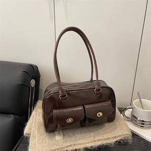 Deep brown glossy leather baguette bag with dual front pockets and golden metal hardware