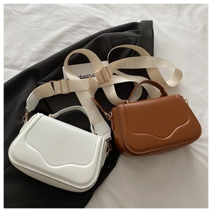 Detail of white and brown leather crossbody bags with adjustable woven shoulder straps