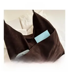 Detailed view of the dark brown suede tote bag featuring convenient front storage pockets
