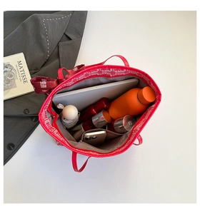 Spacious red tote bag with festive ribbon showing interior storage for tablet and umbrella