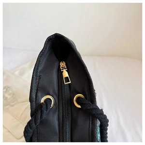 Détail d'un sac cabas en tissu avec fermeture éclair dorée et anses en coton tressé