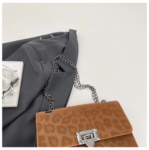 Close-up of leopard print shoulder bag with silver chain strap and metallic lock
