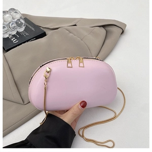 Detail of pink semi-circular bag with golden chain strap and metallic double zippers