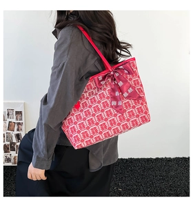 Detail of red bridal tote bag with Double Happiness pattern and large satin bow decoration