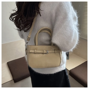Close-up of minimalist cream PU leather crossbody bag with adjustable shoulder strap