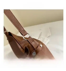Detailed close-up of brown pebbled leather texture and silver metal ring hardware