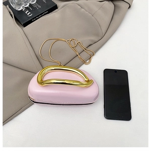 Detail of pink half-moon crossbody bag with gold metal handle and snake chain