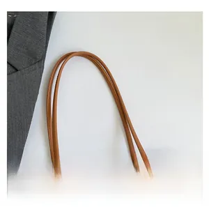Detail of brown lychee grain leather tote bag with printed silk scarf on the handle