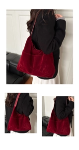 Detailed view of the dark red velvet tote bag showing textured suede and side pockets