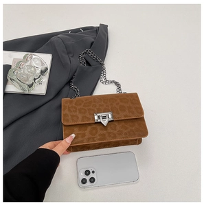 Detail showing leopard print suede bag with metal chain and silver buckle closure