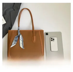 Brown tote bag capacity view with silk scarf detail compared to tablet and phone