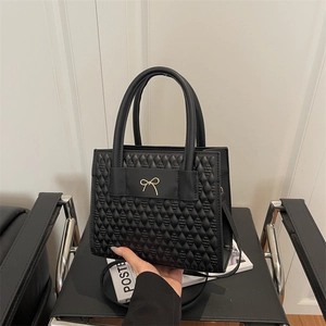 Borsa a mano quadrata nera trapuntata con fiocco dorato e doppi manici eleganti