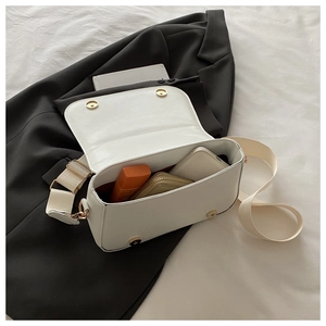 Detail shot of open white square crossbody bag showing spacious interior and golden hardware